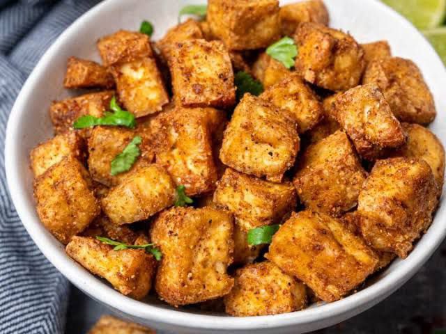 Tofu croutons for soup made in the air fryer, served with parsley in a white bowl.