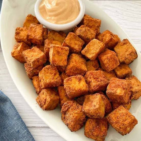 Tofu croutons for soup made in the air fryer and served with creamy sauce in a long white bowl.