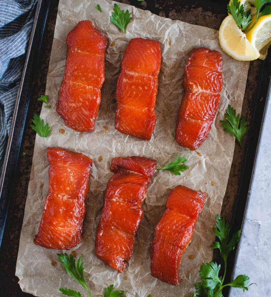 Six pieces of smoked salmon served with lemon and parsley.